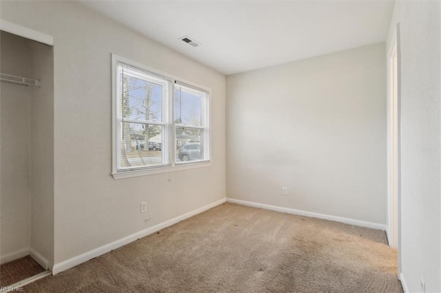 unfurnished bedroom with carpet, visible vents, a closet, and baseboards