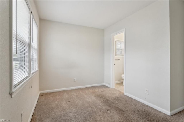 empty room with baseboards and carpet