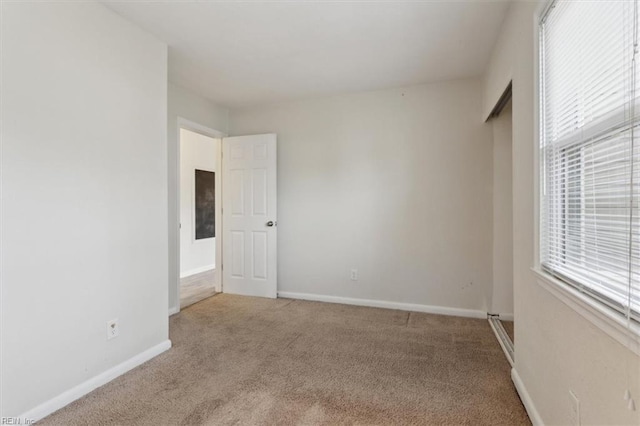 spare room featuring baseboards and carpet flooring