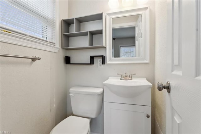 half bathroom featuring vanity and toilet