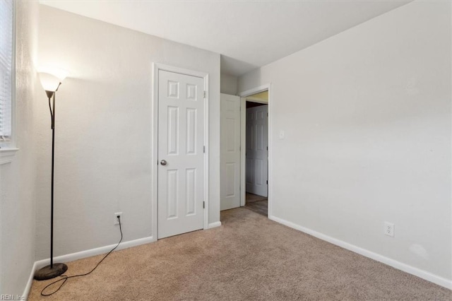 unfurnished bedroom featuring carpet and baseboards