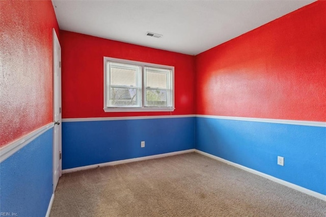 carpeted empty room featuring visible vents and baseboards