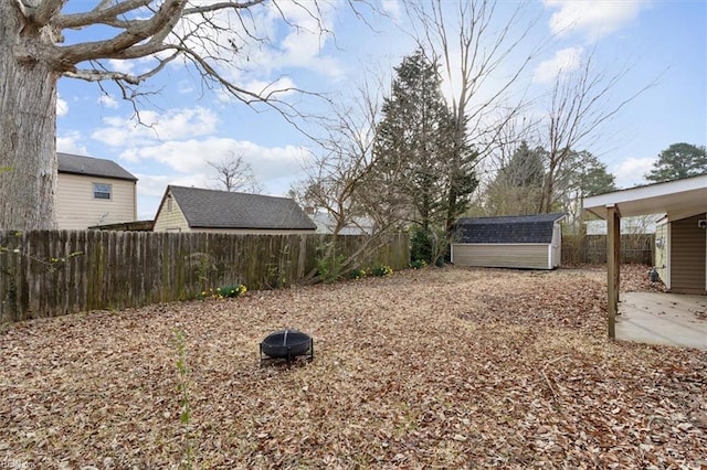 view of yard with a patio area, a shed, an outdoor structure, and a fenced backyard