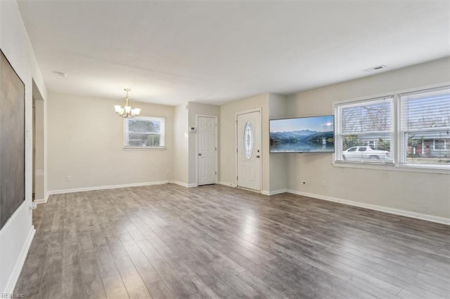 entryway featuring an inviting chandelier, wood finished floors, visible vents, and baseboards