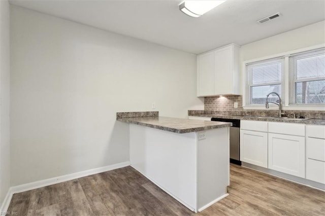 kitchen with a sink, visible vents, stainless steel dishwasher, and wood finished floors