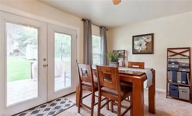 dining room featuring french doors and light colored carpet