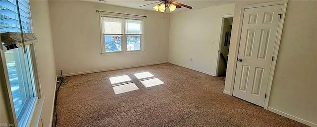 unfurnished room featuring carpet flooring, a ceiling fan, and baseboards