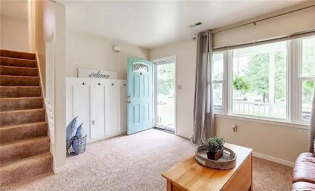 doorway to outside featuring visible vents, stairway, and light colored carpet