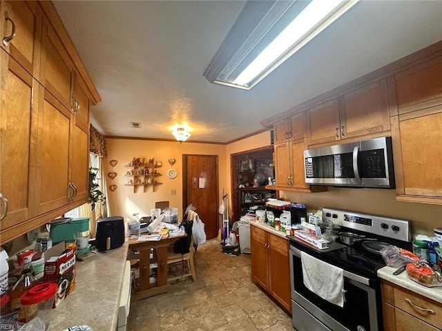 kitchen featuring brown cabinets, appliances with stainless steel finishes, and light countertops