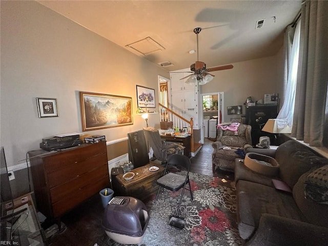 living area featuring a ceiling fan, washing machine and dryer, visible vents, and wood finished floors