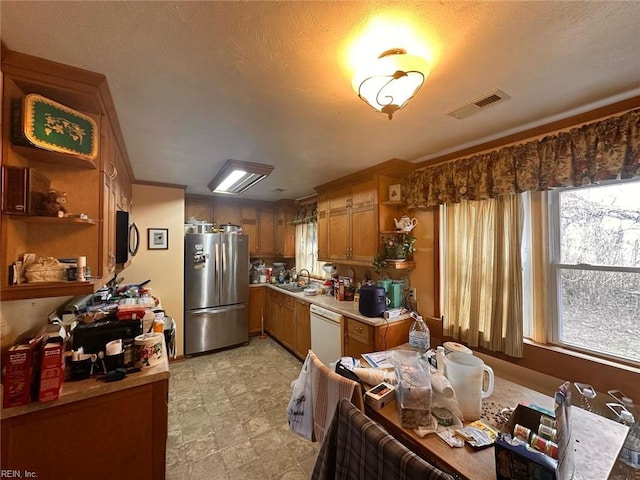 kitchen featuring visible vents, dishwasher, freestanding refrigerator, open shelves, and a sink