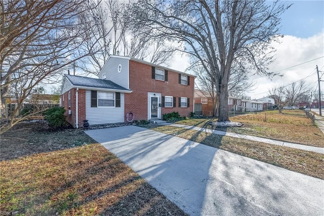 colonial home with brick siding and a front lawn