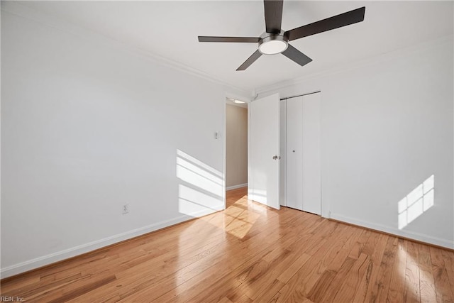 spare room with ornamental molding, light wood-type flooring, ceiling fan, and baseboards