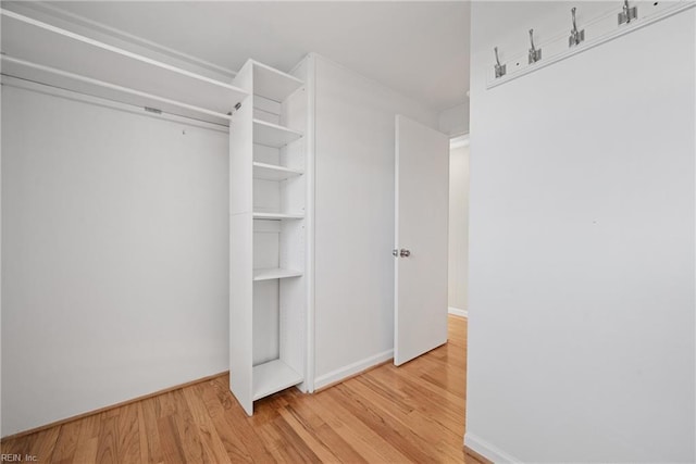 walk in closet with wood finished floors