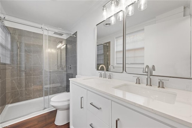 bathroom with a sink, a shower stall, toilet, and wood finished floors