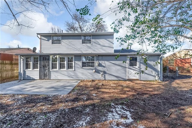 rear view of property with fence and a patio