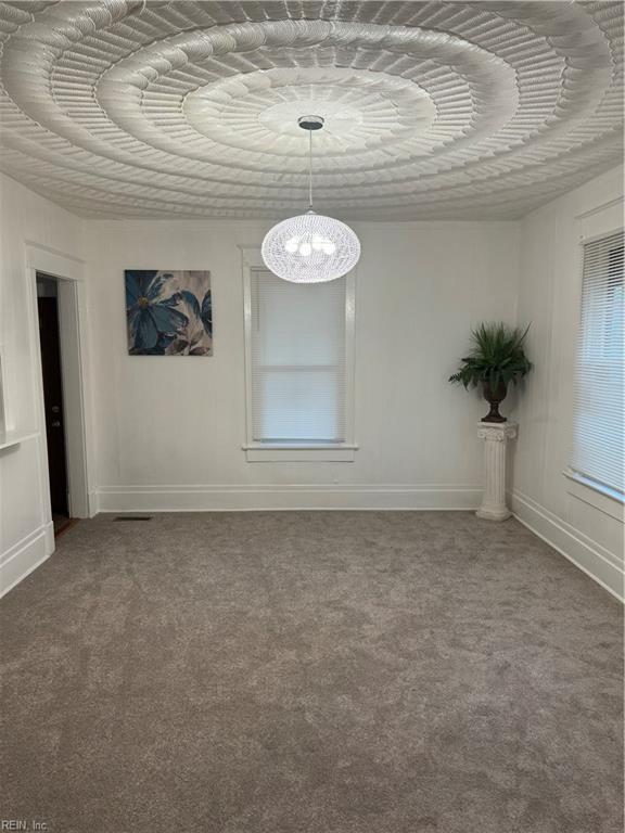 unfurnished room featuring carpet flooring and baseboards