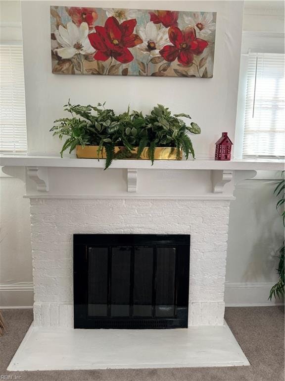 interior details featuring a glass covered fireplace, baseboards, and carpet floors