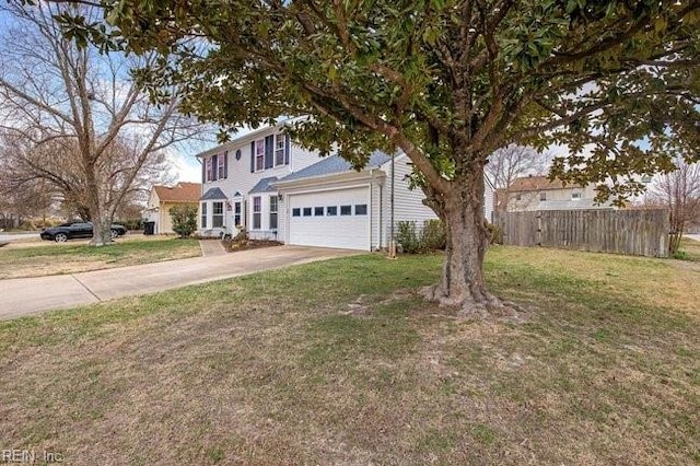 colonial house with a front lawn, concrete driveway, an attached garage, and fence