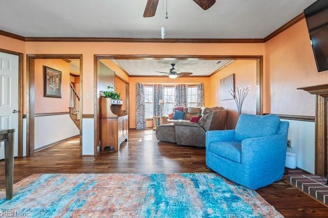 living room with wood finished floors, ceiling fan, and ornamental molding