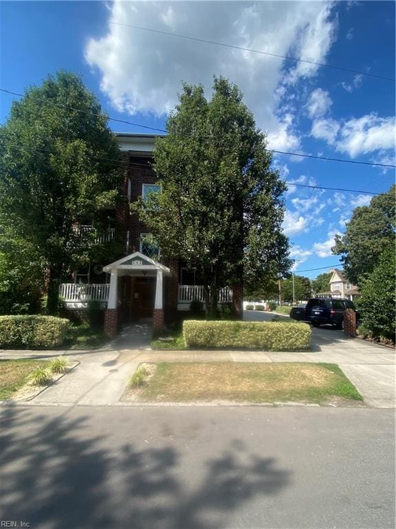 view of front of property featuring brick siding and driveway