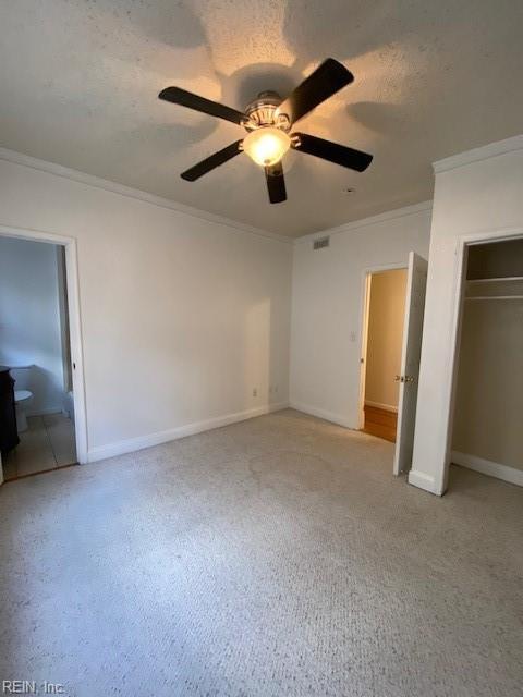 unfurnished bedroom with visible vents, crown molding, baseboards, a closet, and a textured ceiling