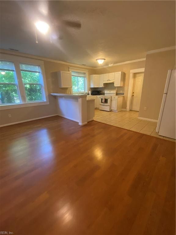 kitchen with light wood-type flooring, ornamental molding, white cabinetry, white appliances, and a peninsula