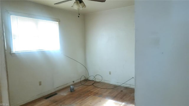 spare room featuring wood finished floors, visible vents, and ceiling fan