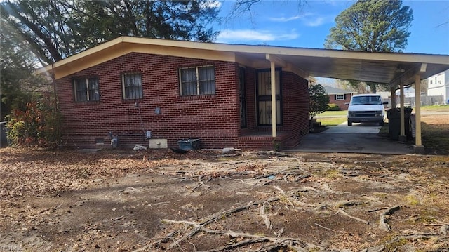 view of property exterior with an attached carport and brick siding