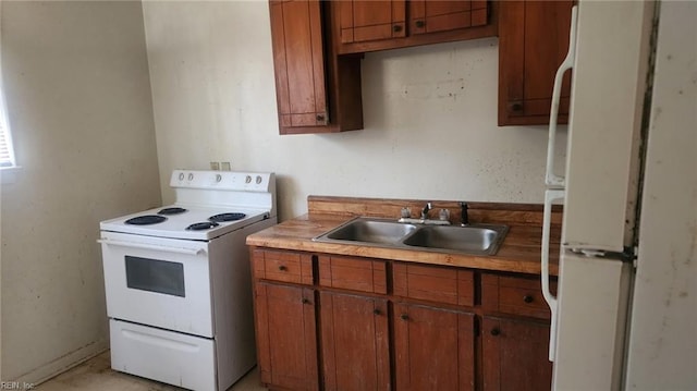 kitchen with a sink, white appliances, brown cabinets, and light countertops