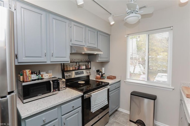 kitchen featuring a healthy amount of sunlight, gray cabinets, under cabinet range hood, and stainless steel appliances