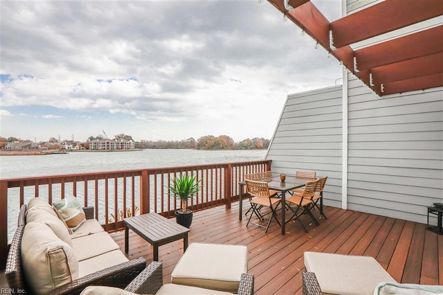 wooden terrace with outdoor dining space, an outdoor living space, and a water view