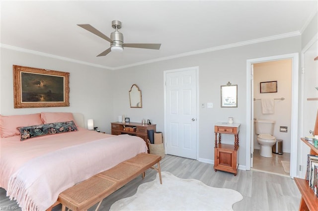 bedroom featuring baseboards, light wood-type flooring, ornamental molding, ensuite bathroom, and a ceiling fan