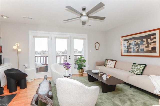 living room featuring visible vents, a ceiling fan, and wood finished floors