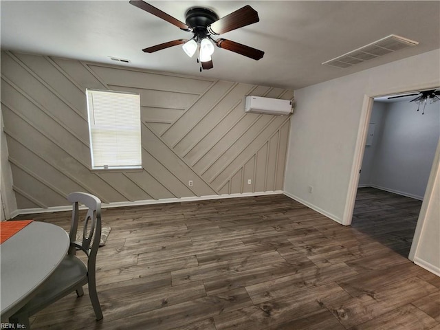 interior space featuring dark wood finished floors, a wall unit AC, and visible vents