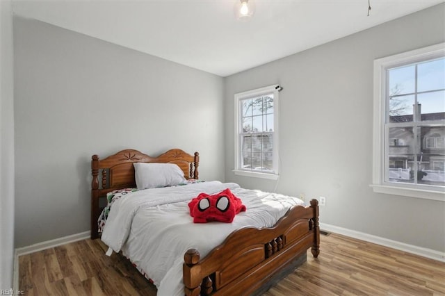 bedroom with baseboards and wood finished floors