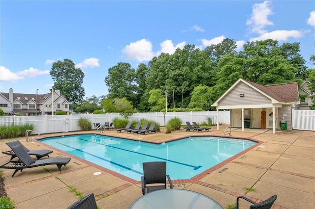 pool with a patio area and fence