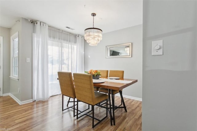 dining area with visible vents, baseboards, and wood finished floors