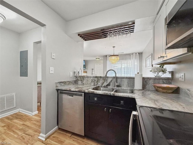 kitchen with visible vents, electric panel, a sink, stainless steel appliances, and light wood-type flooring