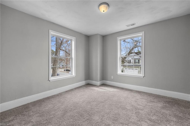 carpeted empty room with visible vents and baseboards