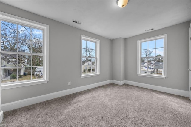 unfurnished room with visible vents, baseboards, and carpet floors