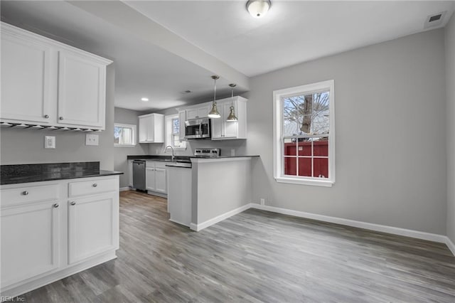 kitchen featuring visible vents, baseboards, white cabinets, appliances with stainless steel finishes, and light wood-type flooring