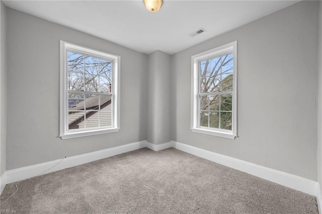 carpeted empty room with visible vents and baseboards