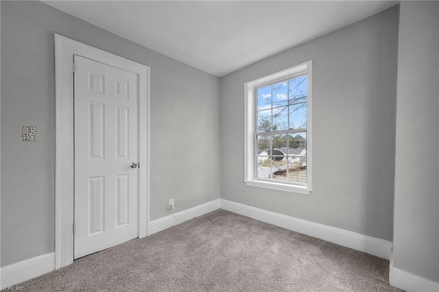 carpeted spare room with baseboards