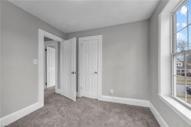 unfurnished bedroom with baseboards and carpet floors