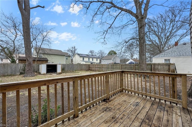 wooden terrace featuring an outdoor structure, a fenced backyard, a residential view, and a shed