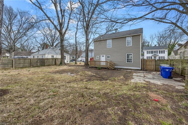 back of house featuring a residential view, a deck, a lawn, and a fenced backyard