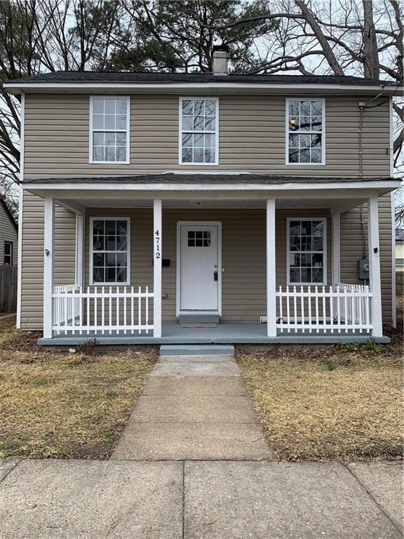 traditional home featuring covered porch and a chimney