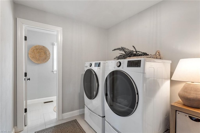 clothes washing area with washer and dryer, visible vents, baseboards, and laundry area