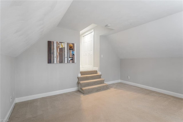 additional living space featuring vaulted ceiling, carpet, and baseboards